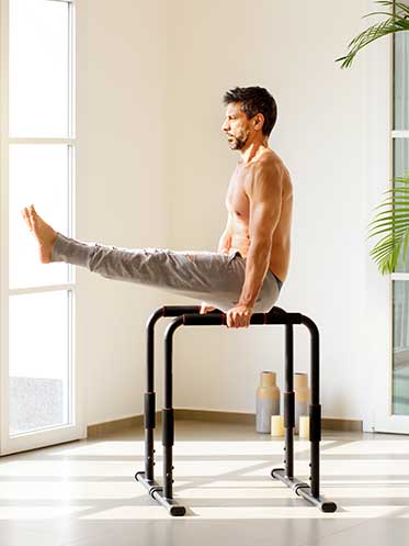 Fit man lifting his body with parallel bars—symbolizing strength, energy, and men’s health after 40.
